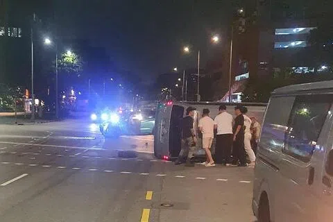 小型货车疑与汽车相撞后侧翻路中央，多名热心公众上前协助。（取自脸书）