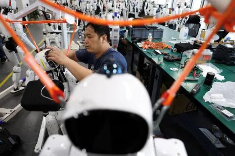 中国监管机构据报正在给一批寻求上市的人形机器人企业“踩刹车”。图为一名工程师9月4日在北京人形机器人创新中心（又称X-Humanoid）的研发测试区内，操作天宫Omni人形机器人。（路透社档案照）