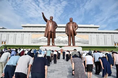 8月15日，朝鲜庆祝解放81周年纪念日。在平壤万寿台，民众向已故朝鲜领导人金日成和金正日雕像鞠躬。（法新社）