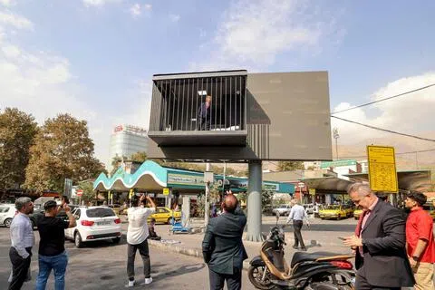 星期三（10月21日）在伊朗德黑兰的塔吉里什广场（Tajrish Square），一名演员戴上美国总统特朗普的面具，在模拟牢房里摆姿态，供民众拍照。（法新社）