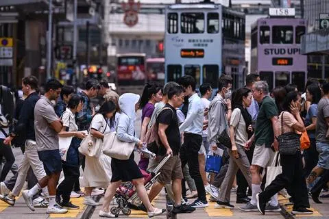 香港的大学近期涌现一连串升学诈骗事件。图为香港行人9月16日穿过中环繁忙的街道。（法新社）