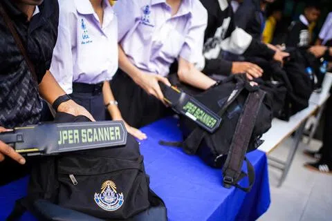 校园暴力袭击案近期频繁出现在东南亚国家，说明这类风险与威胁已经近在咫尺。图为8月19日，在泰国暖武里府发生致命枪击事件后，曼谷一所学校的教师和学生志愿者在安检处使用金属探测器搜寻武器并检查学生的书包。（路透社）