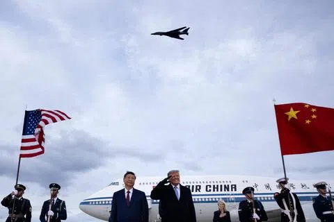 美国总统特朗普（右）9月23日在马里兰州安德鲁斯联合基地亲自迎接到访的中国国家主席习近平（左）。欢迎仪式上，美国国歌奏起，一架美国轰炸机同步飞过，特朗普敬礼。（法新社）