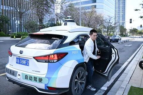 根据中国智能网联电动汽车产业路线图，到2030年，具备自动驾驶功能的汽车将实现规模应用。图为2025年3月，一名乘客在广州南沙区搭乘小马智行自动驾驶无人商业化出租车，在到达目的地后下车。（新华社）