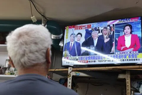 台湾朝野政党对习特会对台影响展开交锋。图为一名男子星期四（9月24日）在台北一家餐厅观看电视新闻，画面显示美国总统特朗普在中国大陆国家主席习近平抵达美国时迎接他。（法新社）