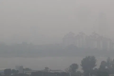 受东南风或西南风影响，烟霾可能继续飘来新加坡，预计本地未来24小时PSI将处于中等偏高水平至中度不健康水平。星期一（10月5日）傍晚6时左右，从加冷河附近向滨海湾花园方向眺望，右方的新加坡摩天观景轮几乎完全看不见。（邬福梁摄）