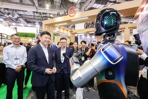 国家发展部长徐芳达（左二）为国际建筑环境周开幕后，参观同时举行的亚洲绿色建筑及室内装饰展，并与策安（Certis）开发的多功能机器人互动。（海峡时报）