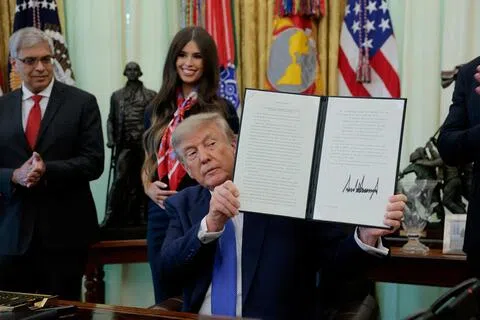 美国总统特朗普星期一（8月10日）在白宫椭圆形办公室签署行政令，全面缩减美国孩童的疫苗接种计划。（路透社）