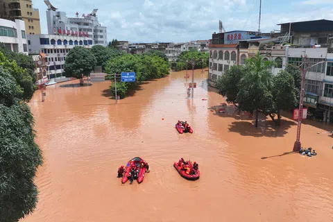 受今年第19号台风“紫檀”影响，中国广西自治区崇左市宁明县多地遭遇持续强降雨天气。图为无人机拍摄的照片，显示救援人员星期二（8月25日）在广西宁明县县城转移受困民（新华社）