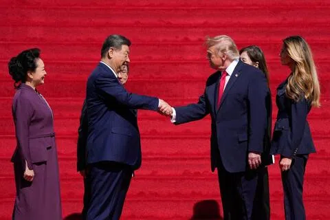 中国国家主席习近平（左二）和美国总统特朗普（左三）星期五在美国华盛顿访问国家档案馆期间握手交谈。习近平夫人彭丽媛（左一）和美国第一夫人梅拉尼娅（左四）在旁陪同。（彭博社）