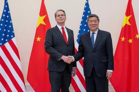 美国财政部长贝森特（左）与中国副总理何立峰今年3月16日在法国巴黎经济合作与发展组织（OECD）总部举行贸易谈判期间握手。（路透社档案照片）