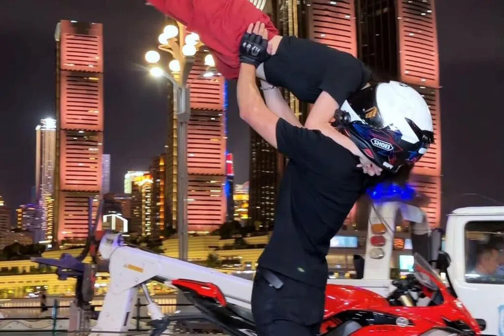 近月在网络人气急升的“重庆机车落地签”，成为不少台湾年轻人赴陆旅游的热门体验。受访者蕙萱（23岁）告诉《联合早报》，出发前，她先在网上搜寻喜欢的骑手，比较不同影片和拍摄风格，再决定自己想要的效果。她选择基础“抱飞”方案，再加人民币100元（约19新元）升级为“举高高、转圈”方案，共人民币498元。（受访者提供）