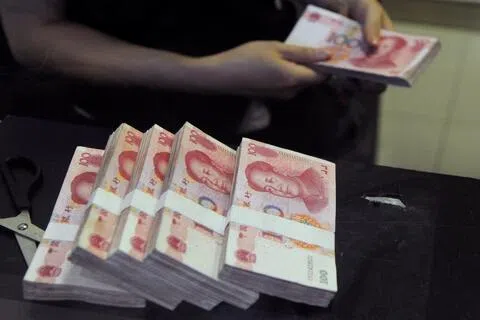 中国7月信贷扩张的表现好于预期，但居民和企业借贷需求疲弱，导致贷款萎缩幅度超过预期。图为中国安徽省合肥市的招商银行分行员工在点算100元人民币现钞，摄于2013年6月。（路透社档案照）