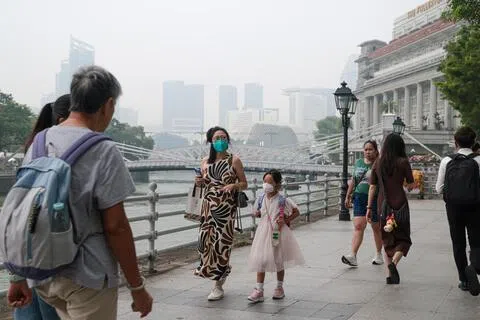 新加坡过去一个多月来持续笼罩在烟霾中，空气素质变糟，一些公众在出门时纷纷戴起了口罩。（李冠卫摄）