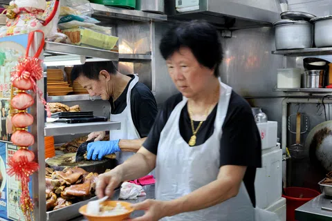 余忠荣（75岁）和林财銮（75岁）夫妻经营了45年的“老两猪脚冻”，即将在10月底歇业。（龙国雄摄）