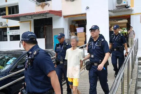 53岁男子星期二下午反锁屋内两个多小时后，被执法人员入屋逮捕，押上警车带走。（陈斌勤摄）