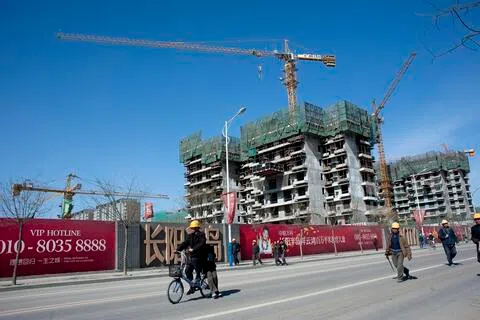 中国房企万科今年上半年亏损扩大至149.5亿元（人民币，下同，约28亿新元），接近此前业绩预告区间上限。图为2011年3月7日，中国北京郊区房山区，建筑工人离开万科住宅项目“Fun City”的施工现场。（彭博社档案照片）