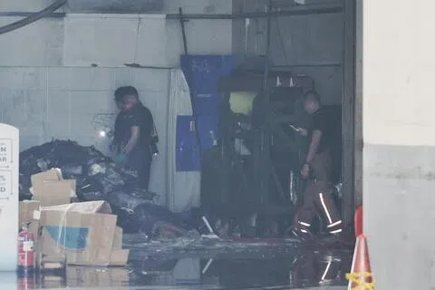 警察和民防人员检查垃圾压缩机内的物品。（徐颖荃摄）
