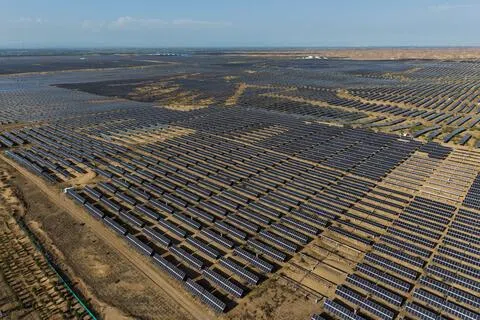 中国风电、太阳能发电合计装机18.4亿千瓦，占总装机比重47.3%。图为6月12日中国内蒙古鄂尔多斯市的库布其沙漠达拉特旗光伏基地内，铺满地面的太阳能电板。（路透社）
