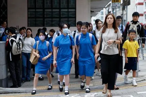 香港星期二（9月1日）迎来新学年开学日，全港中小学生背起书包重返校园。早上不少家长陪同子女上学，校门外人流增加。（香港中通社）