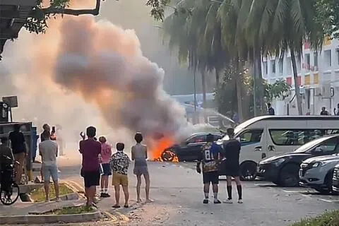 汽车起火，引擎舱遭烈火吞噬，不少公众站在远处围观。（TikTok视频截图）
