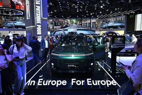 在本月12日至18日举行的法国巴黎车展上，一辆中国车企制造的小鹏G9L汽车前，展示着“立足欧洲、服务欧洲”（In Europe For Europe）的标语牌。（彭博社）