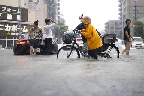 9月8日，日本中部城市名古屋因强降雨淹水，路上行人涉水而过。（路透社）