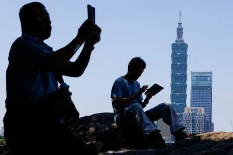 中国大陆领导人习近平访美期间，要求美国“反对台独”并慎重处理台湾问题，引起台湾关注。图为台北民众查阅手机，背景是当地著名地标台北101。（路透社）