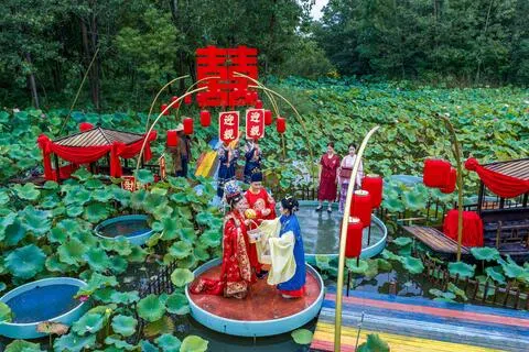 随着婚姻观念改变，中国上半年结婚登记对数继续下滑。图为江苏泗洪洪泽湖湿地景区举办的水上婚礼，摄于7月18日。（新华社）