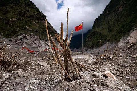 9月6日，洪灾过后，中国西藏自治区日喀则吉隆口岸的原先建筑已荡然无存，救援人员在此插上一面国旗。（路透社）