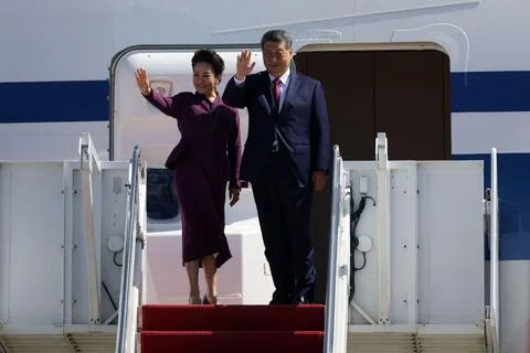 中国国家主席习近平（右）和夫人彭丽媛，当地时间星期五（9月25日）中午12时36分在华盛顿特区外的安德鲁斯联合基地登上专机，准备启程离开美国。（法新社）