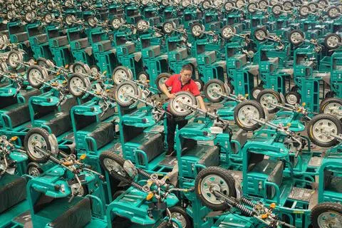 中国7月制造业PMI降至49.2，比6月下降1.1，为五个月来首次跌至萎缩区间。图为山东临沂一名工作人员7月30日在发货前检查电动三轮车。（法新社）