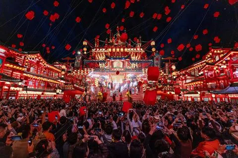 图为10月2日，游客在河北省唐山市丰南区河头老街景区观看表演。（新华社）