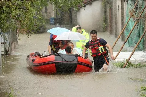 受台风“白海豚”残留低压带来的降雨影响，中国浙江省湖州市德清县出现积水。图为8月14日救援人员拖着载了受灾地区村民的救生船转移。（路透社）