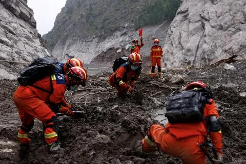 9月6日路透社记者在中国官方组织媒体到西藏吉隆口岸受灾最严重区域进行实地采访，拍摄到中国救援人员开展搜救行动的情景。（路透社）