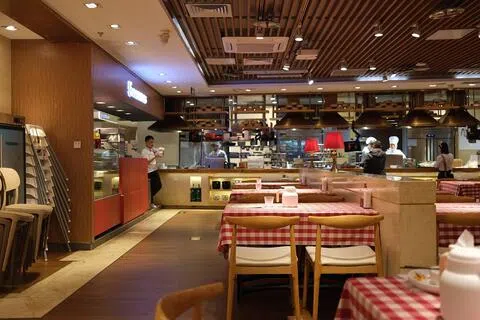 图为2月重庆市中心龙湖时代天街商场的西贝餐饮门店。预制菜风波后，餐厅在工作日午餐时段门可罗雀，员工在有人用餐的桌旁服务，服务员还会为小孩表演魔术。（海峡时报）