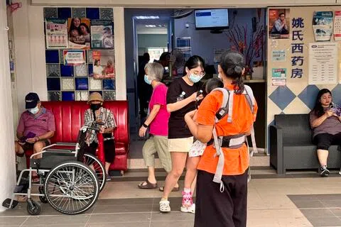 星期五早上，裕廊东一带的诊所外，戴上口罩等候看病的人明显比平常多。（邝启聪摄）