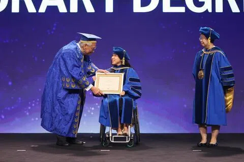 新加坡管理大学授予残障运动员叶品秀（中）名誉法学博士学位，她致辞时鼓励毕业生在追求个人成就的同时，学会尊重差异、理解他人，并勇于挑战偏见。（张俊杰摄）