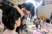 “北漂”妆造师任晓彤在为客户做妆造。妆造师是中国沉浸体验式文旅衍生出的新职业工种。（受访者提供）