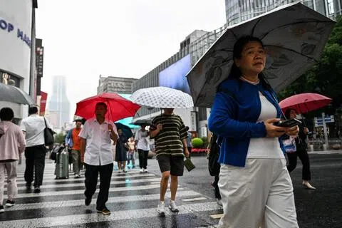 中国国家气候中心说，赤道中东太平洋海水5月至9月快速升温，9月已正式形成一次超强厄尔尼诺事件。图为人们9月30日在上海一街道行走。（法新社）