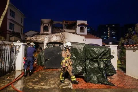洋房几乎被大火完全烧毁，只剩几根残柱；屋顶已经坍塌，窗户也被烧得破碎不堪。屋外的车道则堆满残骸和杂物，现场一片凌乱。（吴先邦摄）