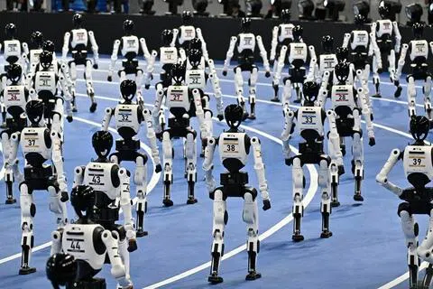 中国机器人领域高速发展，带动新兴职业和工种。图为人形机器人今年8月在北京举行的第二届世界人形机器人运动会开幕式上亮相。（法新社）