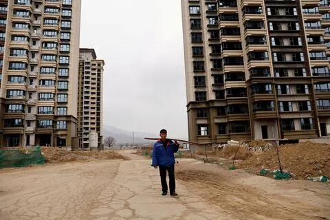 2024年2月1日，中国河北省石家庄市郊，一名男子走过由中国恒大集团开发的未完工住宅楼。（路透社档案照片）