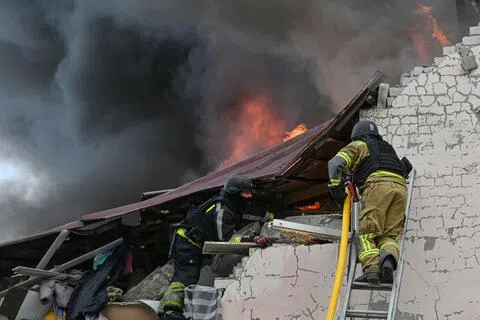 10月5日，乌克兰消防员在哈尔科夫扑灭一处遭俄军空袭的汽车修理厂的火灾。（法新社）