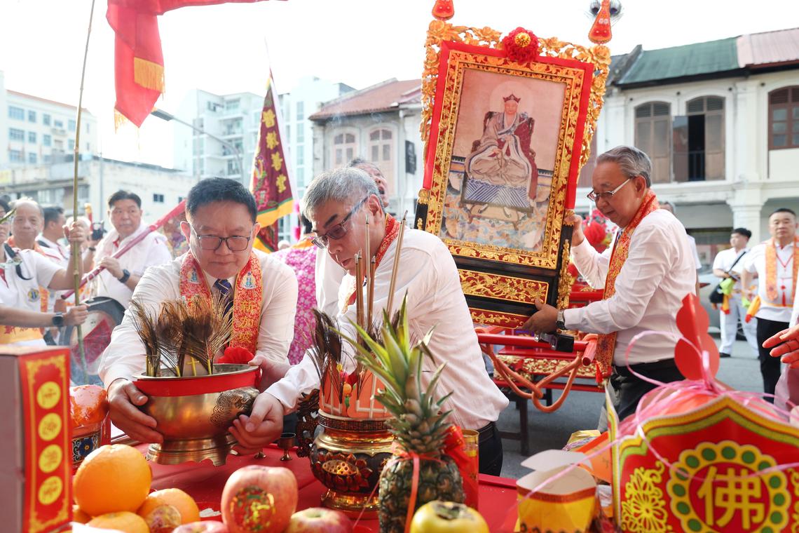 普救善堂总理林怡丰(左)、第一副总理黄伟忠(中)和司理庄永成(右)在林三成香纸庄取香。(郑一鸣摄)
