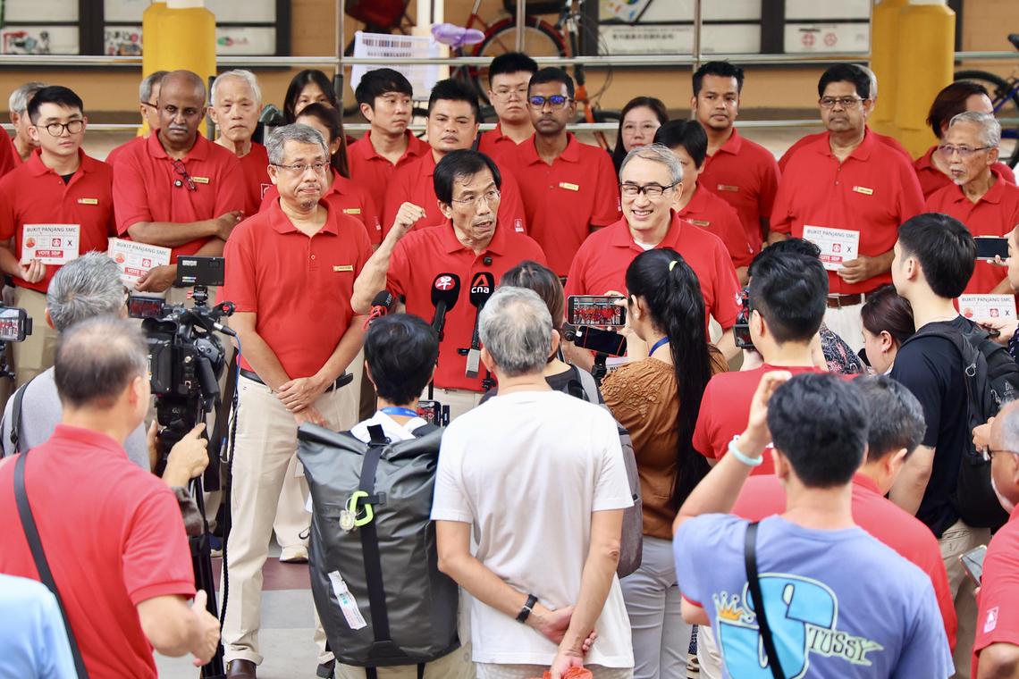 出征三巴旺集选区的新加坡民主党党员达曼胡理(中左起)、秘书长徐顺全,以及党员陈威儒,星期六在万吉组屋区公布竞选口号。(陈斌勤摄)