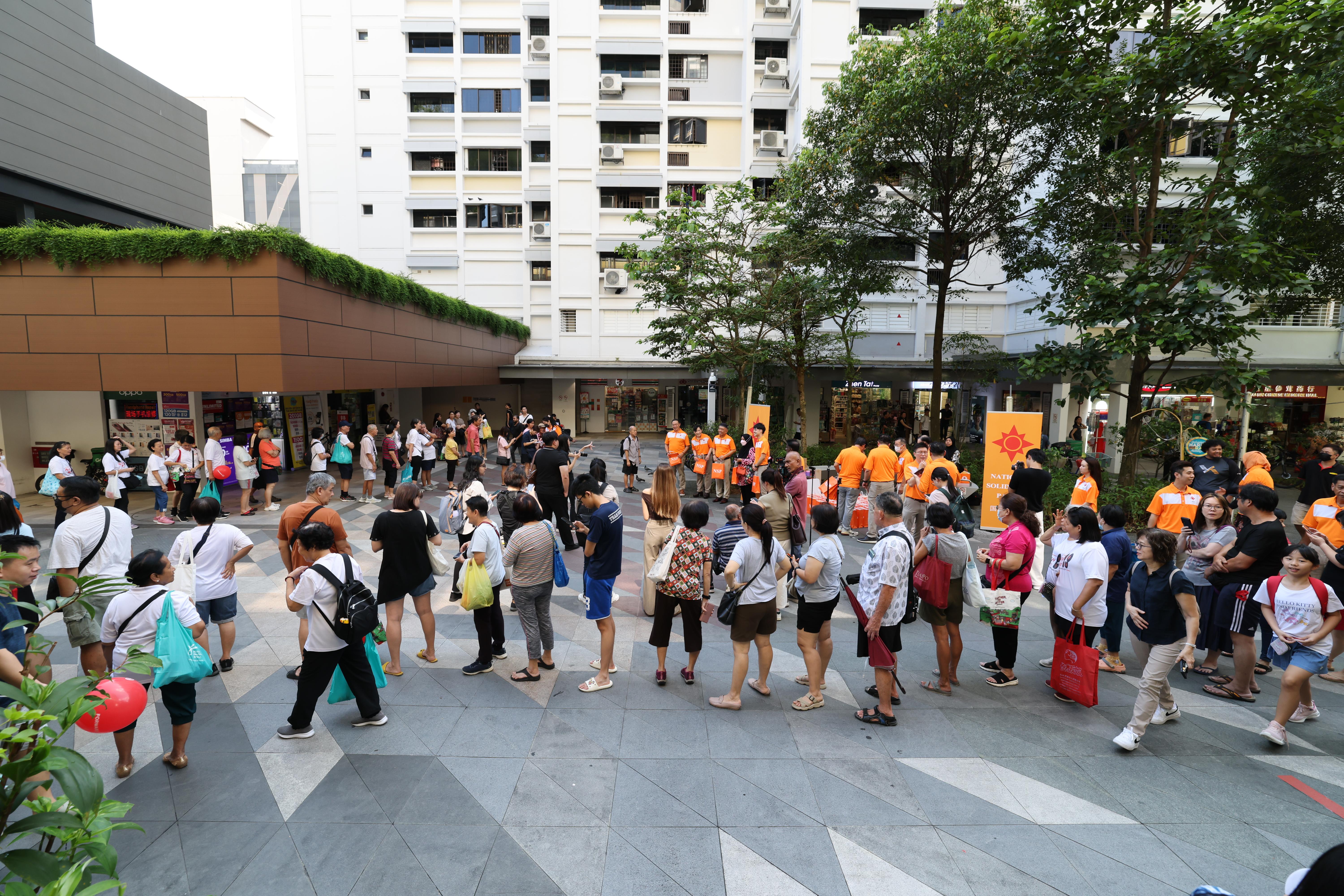 国民团结党团队星期天走访海军部村庄,现场一度有约70名居民排队领取榴梿。(梁麒麟摄)