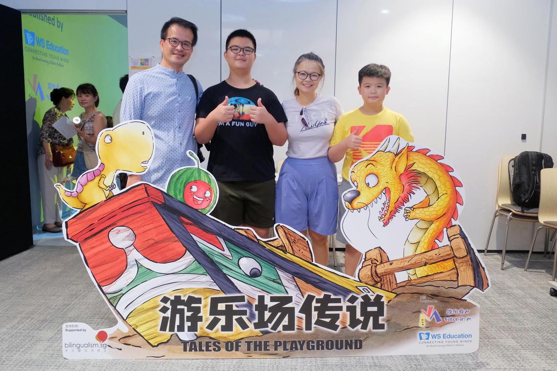 洪益兴(左一)与家人在绘本发布会合影。绘本以本地游乐场为背景,通过亲切熟悉的场景和拟人化角色,激发孩子对华文的兴趣。(受访者提供)