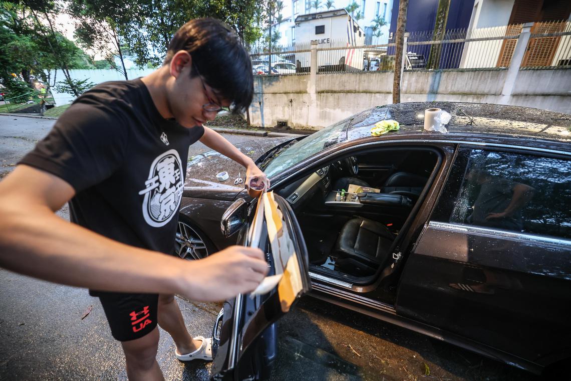 引擎发出怪声、车窗和后备箱关不上,黄亿和和家人只能暂时尝试用胶带修理车窗,等待拖车把车拖走。(关俊威摄)