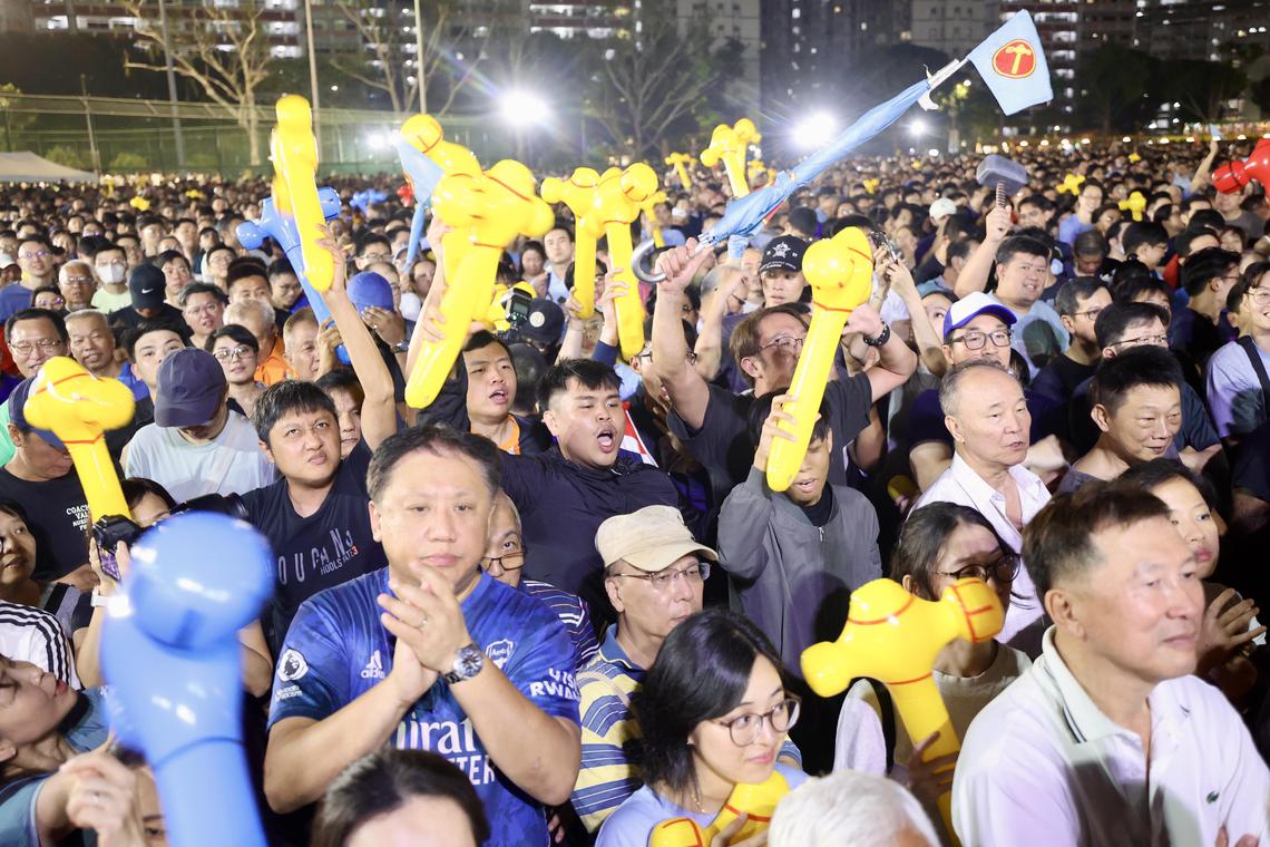 工人党群众大会现场人潮拥挤,主持人还得要求支持者往前移动,让更多人进入草场。住在周边组屋的居民也纷纷站在走廊聆听和观看群众大会。(邝启聪摄)